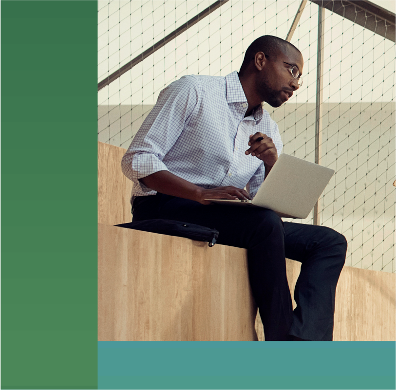 photo of two coworkers having a conversation on bleachers inside of an office presentation room.
